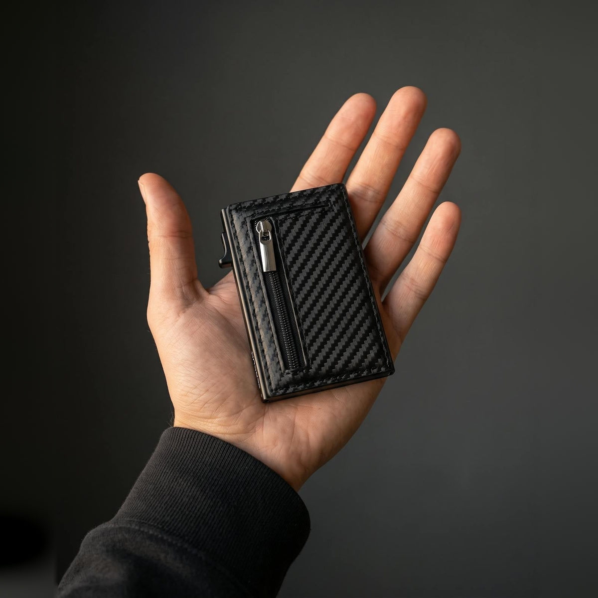 SERCUR CARBON wallet in een hand, zo groot als een bankpas
